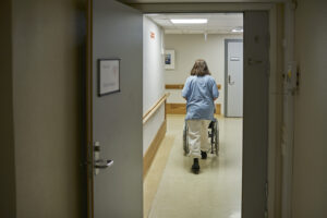 Illustrasjonsfoto av sykepleier som triller pasient på sykehjem