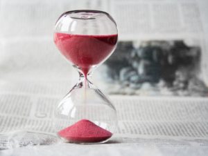 Bilde av et timeglass med rød sand