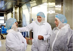 Tre bakeriarbeidere med hvite dresser og blå luer. Foto: Geir Dokken