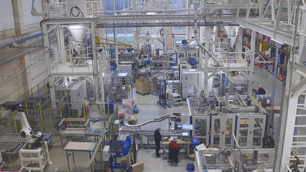 Oversiktsbilde av produksjonslokalet i kaffebrenneriet. Stort lokale der mange maskiner står i glassbur.