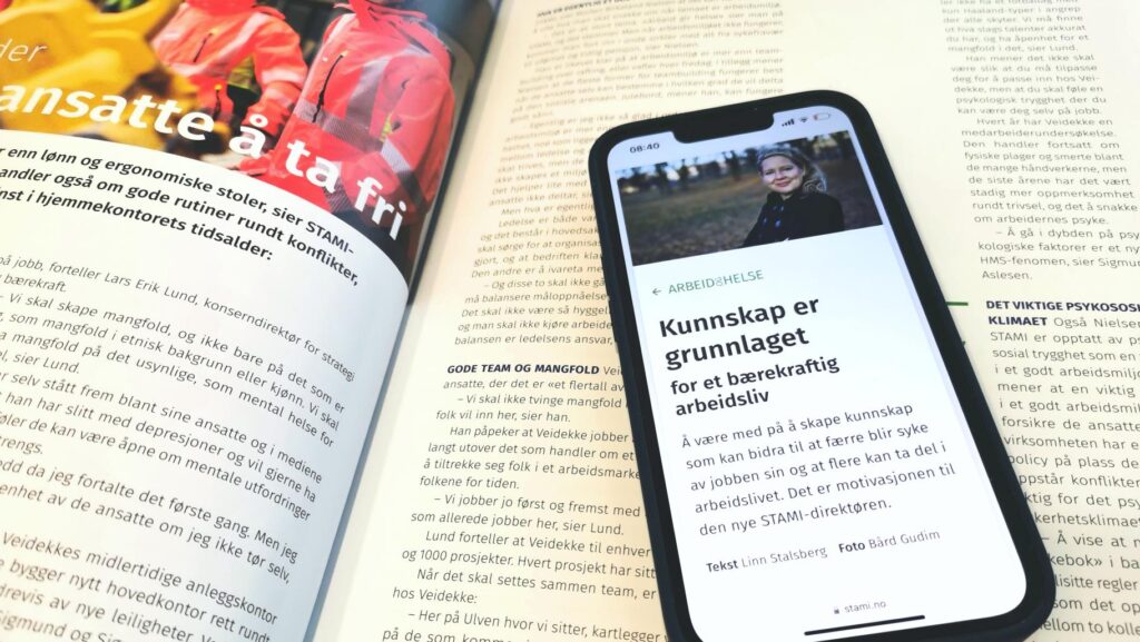 Mobiltelefon med STAMIs digitale magasin på skjermen, ligger på en tidligere versjon av STAMIs papirmagasin.