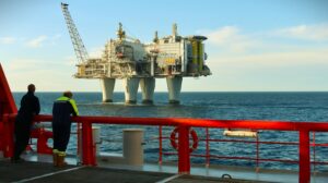 To personar på eit skipsdekk ser på ein oljeplattform i Nordsjøen.