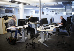 Tre kolleger jobber sammen i delt kontor.