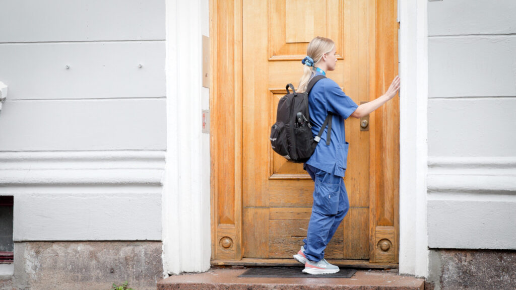 Ein heimesjukepleiar ringer på, utanfor ein bygård