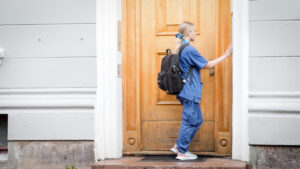 Ein heimesjukepleiar ringer på, utanfor ein bygård