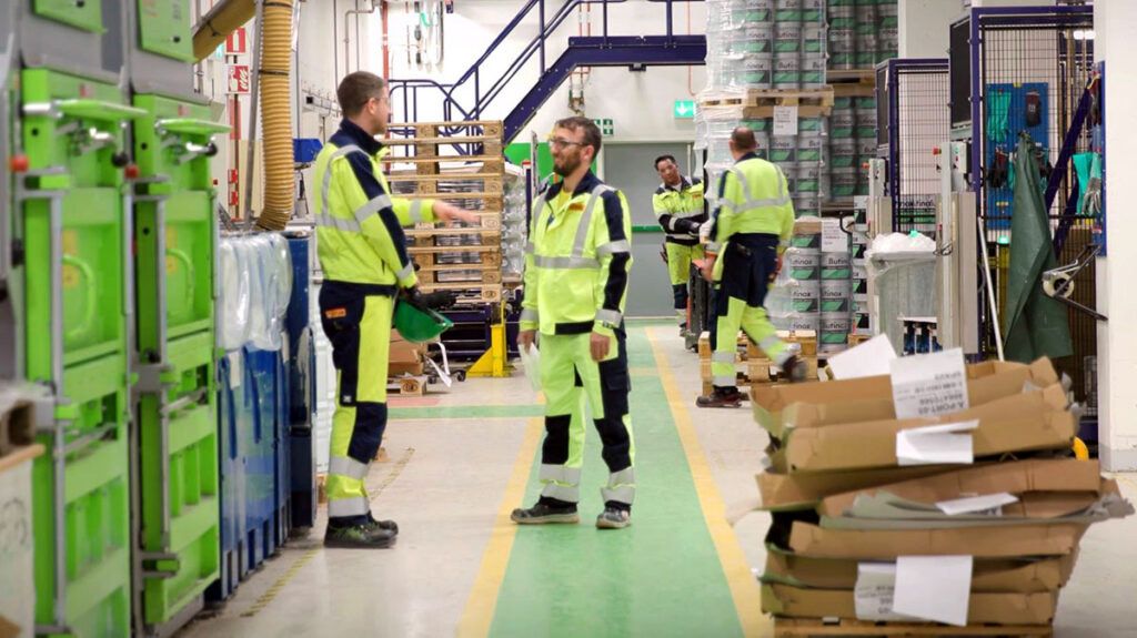 Kollegaar i eit produksjonslokale snakkar saman